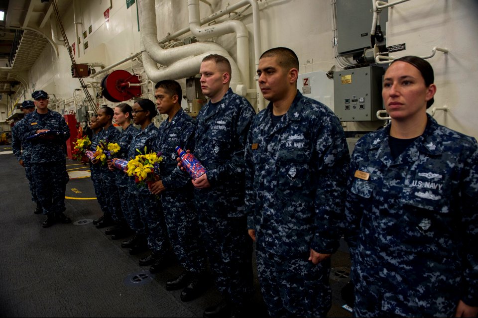 U.S. Navy chief petty officer selects stand at attention as they prepare for a 9-11 remembrance ceremony in the hangar bay aboard the newly commissioned amphibious assault ship USS America (LHA 6) Sept 140911-N-MD297-011