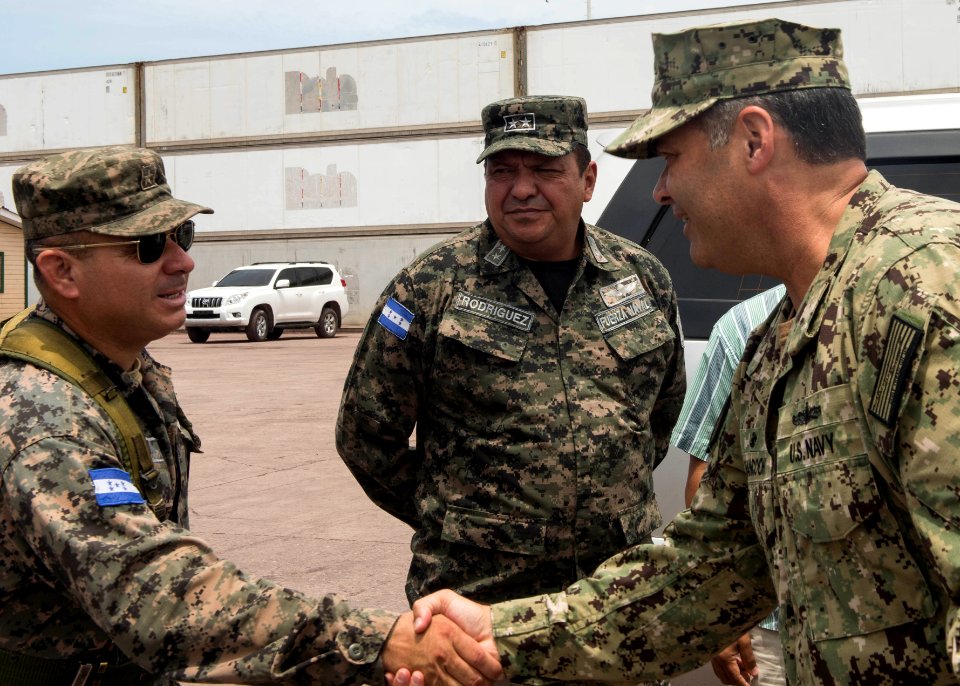 U.S. Navy Capt. Sam Hancock, right, the mission commander for Southern Partnership Station (SPS) 2014 operations aboard the joint high speed vessel USNS Spearhead (JHSV 1), greets Honduran military officials 140901-N-QY430-100