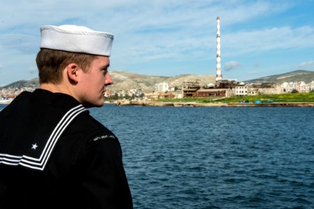 U.S. Navy Fire Controlman 3rd Class Stephen Ray mans the rails aboard the guided missile cruiser USS Philippine Sea (CG 58) as it moors in Piraeus, Greece, for a scheduled liberty port visit March 4, 2014 140304-N-PJ969-278