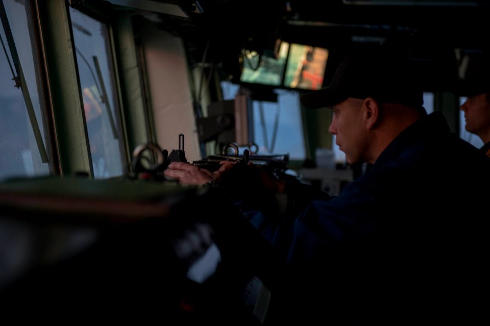 U.S. Navy Chief Warrant Officer Travis Meyer takes a bearing aboard the guided missile destroyer USS Stout (DDG 55) as the ship prepares to pull into port in Haifa, Israel, Jan. 19, 2014, for a scheduled port 140119-N-UD469-173