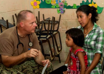 U.S. Navy Cmdr. Michael Cackovic, left, a medical officer attached to the Naval Reserve Expeditionary Medical Facility, tends to Guatemalan patients at a medical civic action project (MEDCAP) in Puerto Barrios 140823-N-QY430-586 photo