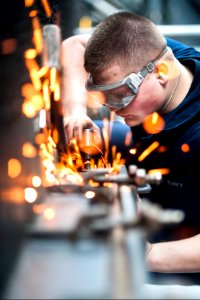 U.S. Navy Hull Maintenance Technician Fireman Apprentice Michael Crawford repairs a weather safety pin on a watertight hatch aboard the aircraft carrier USS Harry S. Truman (CVN 75) in the Gulf of Oman March 15 140315-N-ZG705-192