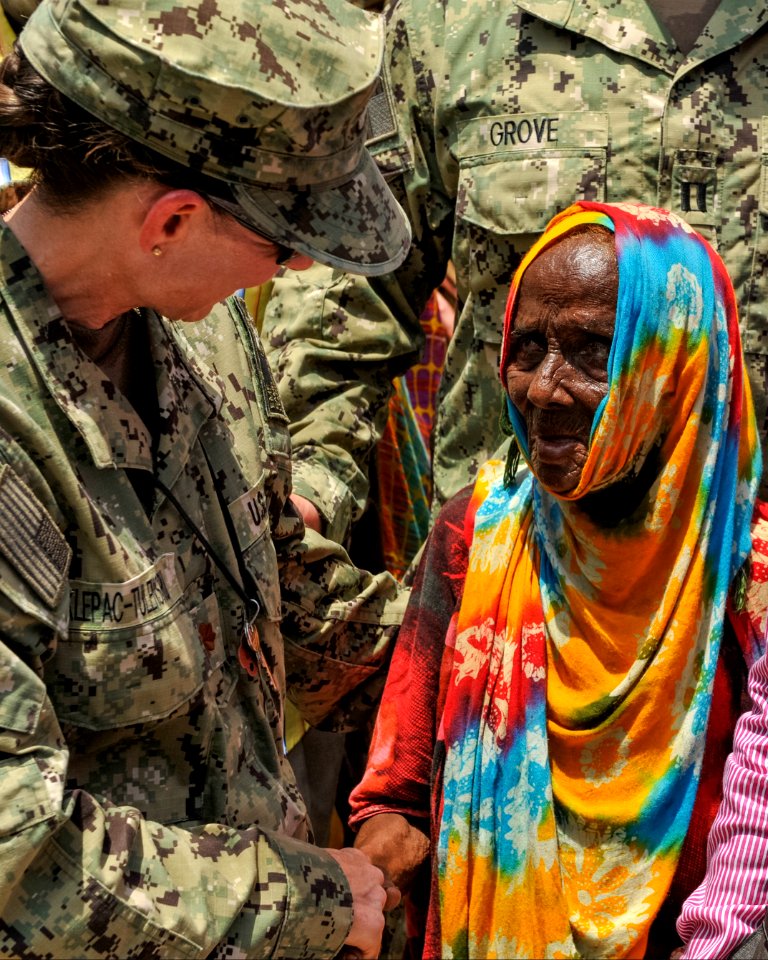 U.S. Navy Lt. Cmdr. Pamela Klepac-Tulensru, left, the officer in charge of the expeditionary medical facility at Camp Lemonnier, Djibouti, exchanges greetings with a Djiboutian woman at the home of a community 140409-N-LE393-137