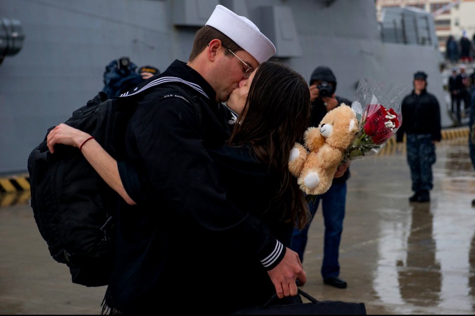 U.S. Navy Cryptologic Technician (Collection) 2nd Class Christopher Ferguson kisses his girlfriend after the guided missile destroyer USS Bainbridge (DDG 96) returned to Naval Station Norfolk, Va., Jan. 14 140114-N-VC236-083