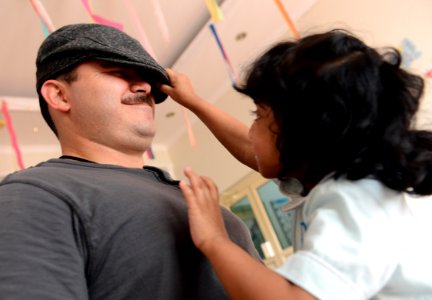 U.S. Navy Lt. David Campbell, left, assigned to the Maritime Civil Affairs Team with Commander, Task Force (CTF) 56, interacts with a little girl during a community relations event at the Regional Institute for 131127-N-OU681-389