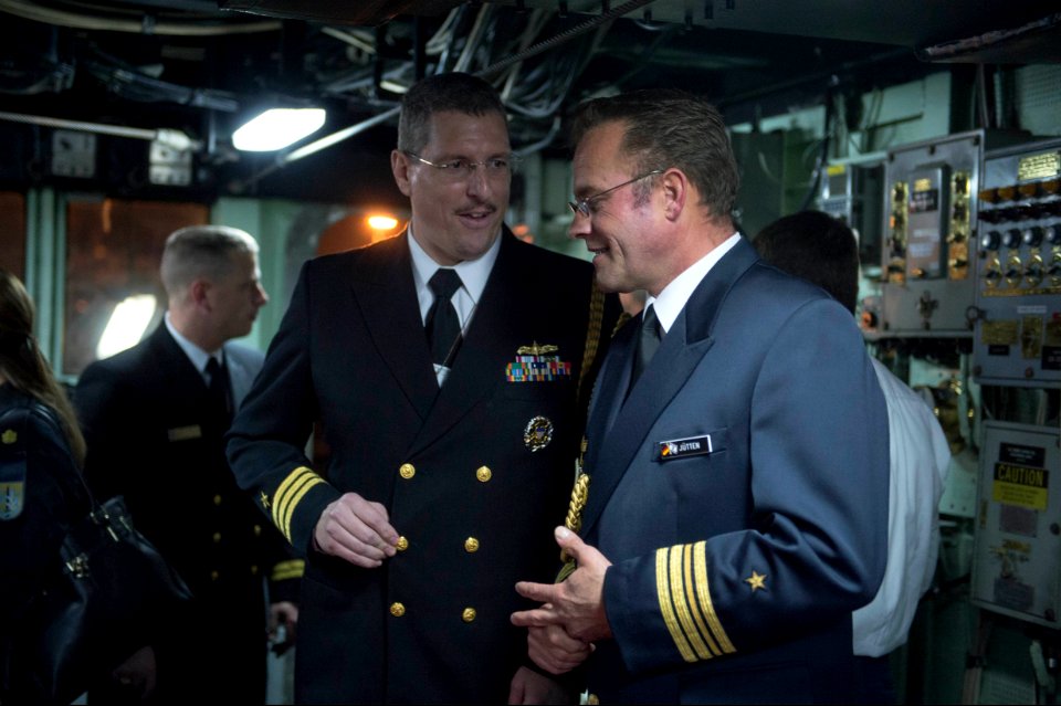 U.S. Navy Cmdr. Sean Maxwell, left foreground, and German navy Cmdr. Stephan Jutten, both attaches to Israel, speak during a reception on the bridge of the guided missile destroyer USS Stout (DDG 55) 140120-N-UD469-813