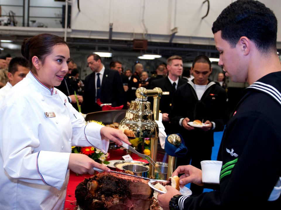 U.S. Navy Culinary Specialist Seaman Recruit Laura Osorio, left, serves food during a reception aboard the amphibious assault ship USS America (LHA 6) Aug. 25, 2014, in Valparaiso, Chile 140825-N-LQ799-082
