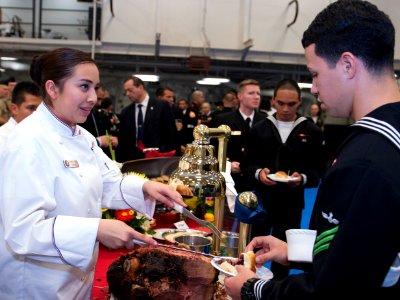 U.S. Navy Culinary Specialist Seaman Recruit Laura Osorio, left, serves food during a reception aboard the amphibious assault ship USS America (LHA 6) Aug. 25, 2014, in Valparaiso, Chile 140825-N-LQ799-082