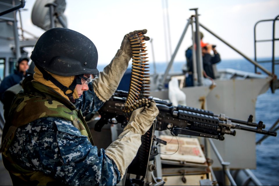 U.S. Navy Electronics Technician 3rd Class Dillon Fair, assigned to the amphibious transport dock ship USS Denver (LPD 9), loads ammunition into an M240B machine gun before a live-fire exercise March 10, 2014 140310-N-ZU025-009