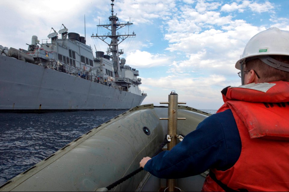 U.S. Navy Ensign Matthew Blackmon, assigned to the guided missile destroyer USS Stout (DDG 55), prepares to come alongside the ship on a rigid-hull inflatable boat during small-boat operations Jan. 14, 2014 140114-N-UD469-129