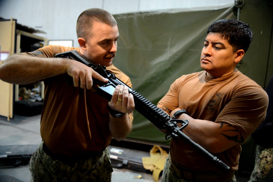 U.S. Navy Electronics Technician 1st Class Garrett Swanson, left, and Boatswain's Mate 1st Class Eddie Montalvo, both assigned to Commander, Task Force (CTF) 56, conduct weapons training at Naval Support 140212-N-OU681-118