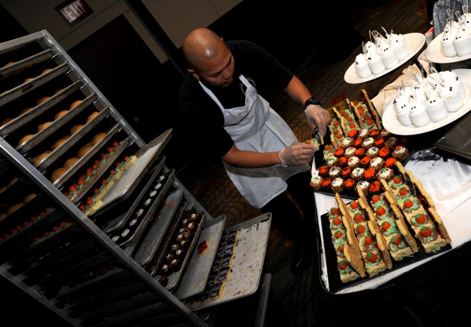 U.S. Navy Culinary Specialist 1st Class Rheden Mones, assigned to the amphibious assault ship Pre-Commissioning Unit America (LHA 6), arranges Halloween-themed desserts during culinary training at Mignon's 131031-N-LQ799-072