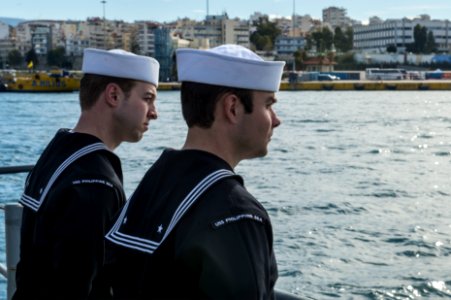 U.S. Navy Electronics Technician 3rd Class Dwayne Reinike, left, and Electronics Technician 3rd Class Brandon McCandless man the rails aboard the guided missile cruiser USS Philippine Sea (CG 58) as it moors 140304-N-PJ969-288