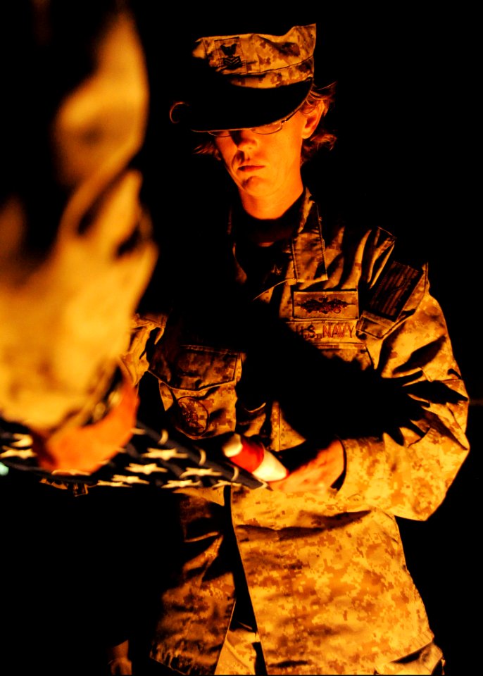 U.S. Navy Logistics Specialist 1st Class Krystal Cicenas, selected as a chief petty officer assigned to Naval Mobile Construction Battalion 25, folds a ceremonial U.S. flag flown in remembrance of 9-11 at 140911-N-JP566-244
