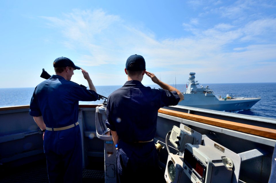 U.S. Navy Lt. j.g. Robert Vann salutes the Turkish corvette TCG Heybeliada (F 511) from aboard the guided missile destroyer USS Ross (DDG 71) in the Mediterranean Sea during a passing exercise Sept 140902-N-IY142-136