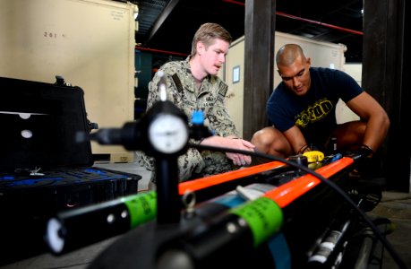 U.S. Navy Explosive Ordnance Disposal (EOD) Technician 2nd Class Michael Ganousis, left, and EOD Technician 3rd Class Troy Padmore, both assigned to a mine countermeasures team with Commander, Task Group (CTG) 140209-N-OU681-141 photo