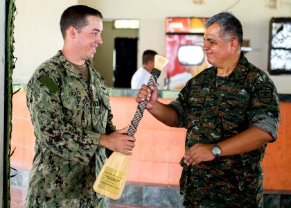 U.S. Navy Lt. Sean Tucker, left, assigned to Coastal Riverine Squadron 2, gives a gift of appreciation to Guatemalan Ship's Capt. Saul Arnoldo Tobar Garcia, the second in command of the Guatemalan Marine 140822-N-XQ474-229