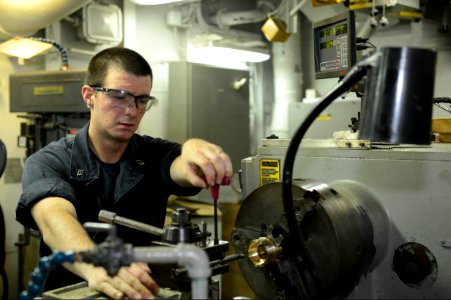 U.S. Navy Machinery Repairman Fireman Timothy Grover works on the amphibious assault ship USS Bataan (LHD 5) in the U.S. 5th Fleet area of responsibility June 28, 2014 140628-N-MW280-055