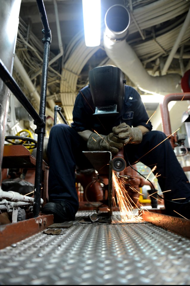 U.S. Navy Hull Maintenance Technician 3rd Class Alexander Cole rebuilds a nitrogen bottle bracket aboard the amphibious assault ship USS Bataan (LHD 5) in the U.S. 5th Fleet area of responsibility June 30, 2014 140630-N-MW280-023