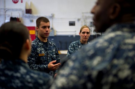 U.S. Navy Cryptologic Technician (Networks) 1st Class Kurt Myers, center left, selected for promotion to chief cryptologic technician, discusses the plan of events with fellow petty officers 1st class selected 140907-N-MD297-111
