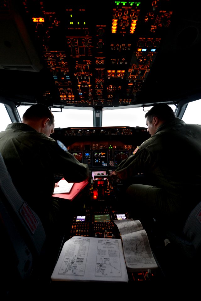 U.S. Navy Lt. j.g. Nick Horton, left, and Lt. Clayton Hunt, naval aviators assigned to Patrol Squadron (VP) 16, perform preflight checks in the flight station of a P-8A Poseidon aircraft before a mission to 140401-N-VD564-048