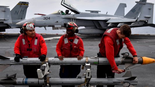 U.S. Navy personnel prepare to load a CATM-9X missile onto an aircraft aboard the USS Nimitz (CVN 68) during Malabar 2017