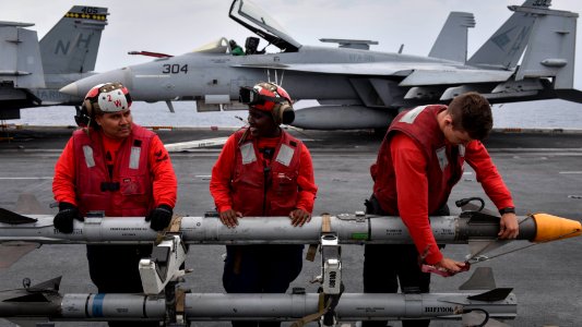 U.S. Navy personnel prepare to load a CATM-9X missile onto an aircraft aboard the USS Nimitz (CVN 68) during Malabar 2017 photo