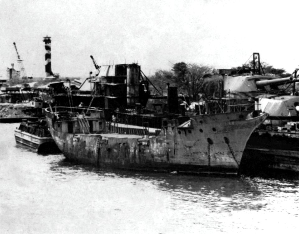 U.S. Navy sludge removal barge YSR-42 alongside of USS Oklahoma (BB-37) at Pearl Harbor, circa in 1944