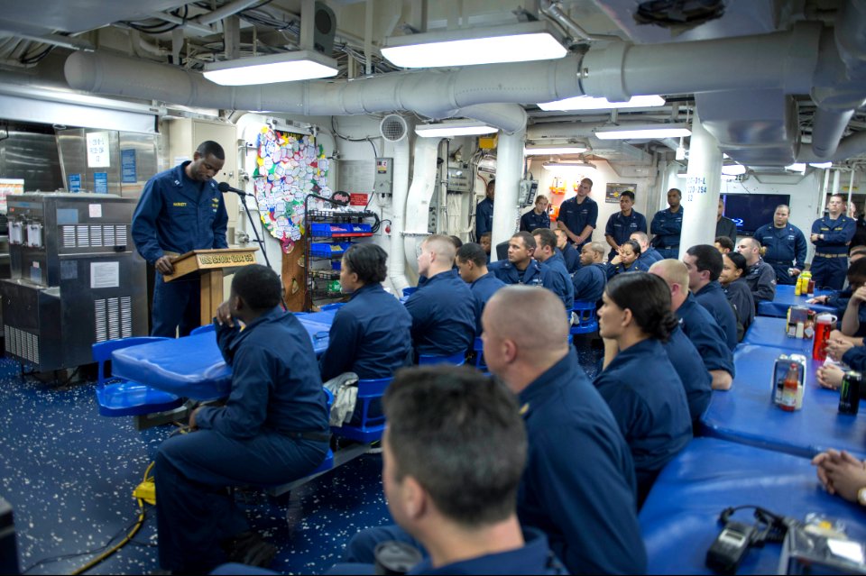 U.S. Navy Lt. Luqman Haskett, at lectern, addresses Sailors aboard the guided missile destroyer USS Stout (DDG 55) during a commemoration ceremony honoring Dr. Martin Luther King Jr 140118-N-UD469-618