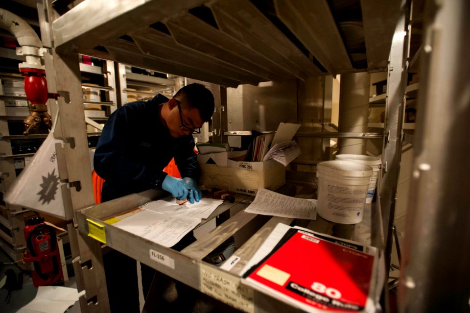 U.S. Navy Seaman Shilong Zhou organizes hazardous materials receipts aboard the amphibious assault ship USS America (LHA 6) Sept 140905-N-MZ309-028