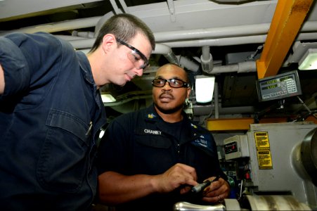 U.S. Navy Machinery Repairman 1st Class Thomas Chaney, right, and Machinery Repairman Fireman Timothy Grover work on the amphibious assault ship USS Bataan (LHD 5) in the U.S. 5th Fleet area of responsibility 140628-N-MW280-025