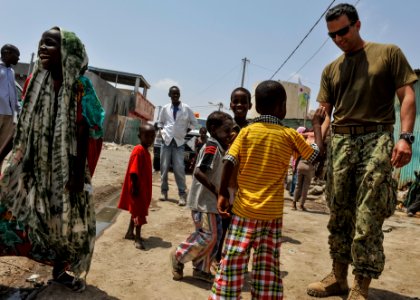 U.S. Navy Lt. j.g. Brian Tribble, right, plays with children in Djibouti city April 9, 2014 140409-N-LE393-074