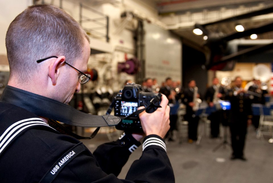 U.S. Navy Mass Communication Specialist 1st Class Jason Graham records video of a Chilean band during a reception aboard the amphibious assault ship USS America (LHA 6) Aug. 25, 2014, in Valparaiso, Chile 140825-N-LQ799-110