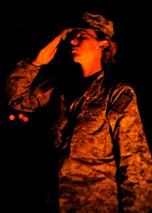 U.S. Navy Logistics Specialist 1st Class Krystal Cicenas, selected as a chief petty officer assigned to Naval Mobile Construction Battalion 25, salutes as a ceremonial U.S. flag is flown in remembrance of 9-11 140911-N-JP566-233