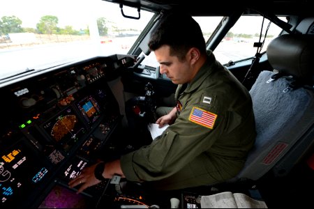 U.S. Navy Lt. Clayton Hunt, a naval aviator assigned to Patrol Squadron (VP) 16, performs preflight checks in the flight station of a P-8A Poseidon aircraft before a mission to assist in search and recovery 140401-N-VD564-064