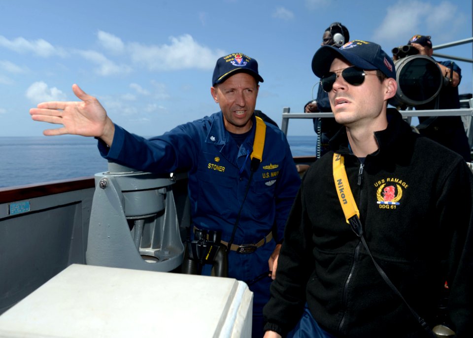 U.S. Navy Cmdr. John D. Stoner, left, the commanding officer of the guided missile destroyer USS Ramage (DDG 61), instructs Ensign Matthew Taber, a conning officer, as the ship conducts small boat operations 140409-N-CH661-625