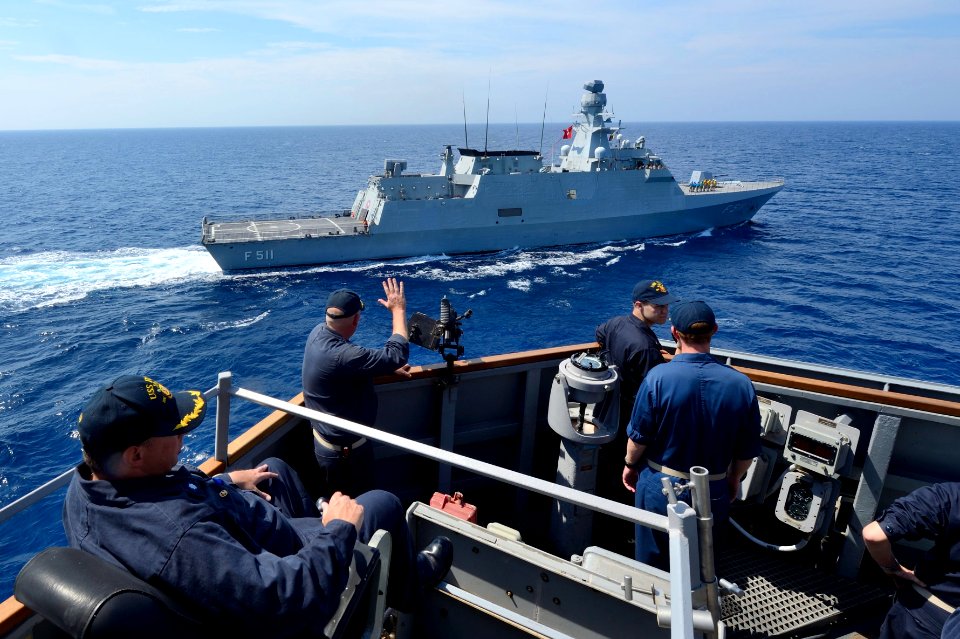 U.S. Navy Cmdr. Russell Caldwell waves to the Turkish corvette TCG Heybeliada (F 511) from aboard the guided missile destroyer USS Ross (DDG 71) in the Mediterranean Sea during a passing exercise Sept 140902-N-IY142-159