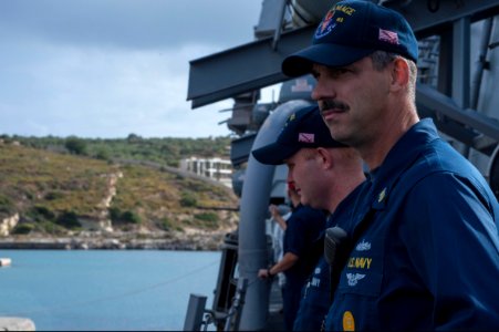 U.S. Navy Command Master Chief Joseph O'Brien, right, and Gas Turbine System Technician (Electrical) 1st Class Jared Guidry stand on the deck of the guided missile destroyer USS Ramage (DDG 61) as the ship 131107-N-VC236-022