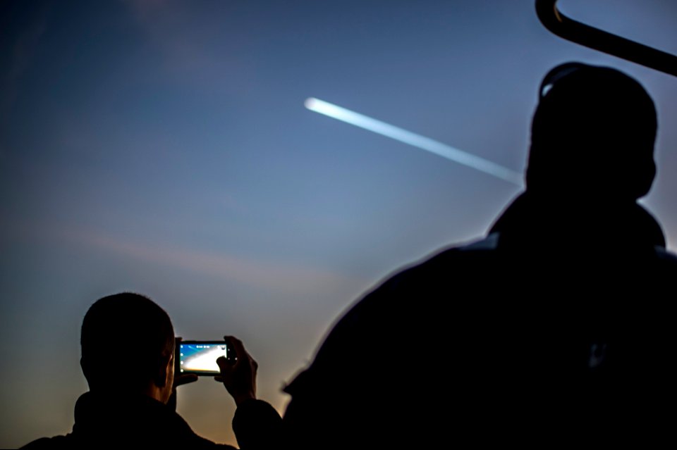 U.S. Sailors aboard the guided missile cruiser USS Philippine Sea (CG 58) in the Atlantic Ocean watch as a satellite enters the atmosphere Dec. 3, 2013 131203-N-PJ969-041
