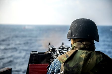U.S. Navy Electronics Technician 3rd Class Dillon Fair fires an M240B machine gun during a live-fire exercise aboard the amphibious transport dock ship USS Denver (LPD 9) March 10, 2014, in the East China Sea 140310-N-ZU025-131