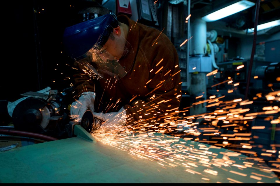 U.S. Navy Machinery Repairman Fireman Apprentice Nathaniel Molina removes a hinge from a watertight door in the general workshop aboard the guided missile destroyer USS Ramage (DDG 61) Dec. 1, 2013, at Naval 131201-N-VC236-022