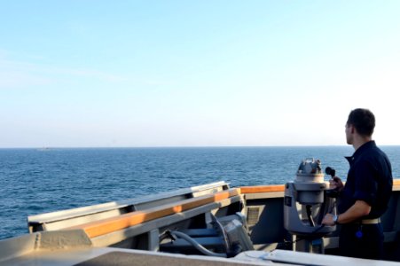 U.S. Navy Ensign Jonathan Larson observes the Romanian corvette Contre Admiral Eustatiu Sebastian (F 264) from aboard the guided missile destroyer USS Ross (DDG 71) during a passing exercise in the Black Sea 140907-N-IY142-255