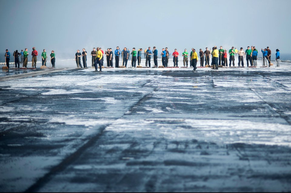 U.S. Sailors and Marines scrub the flight deck of the aircraft carrier USS Harry S. Truman (CVN 75) March 16, 2014, in the Gulf of Oman 140316-N-ZG705-479