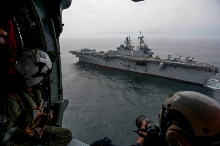 U.S. Navy Mass Communication Specialist 2nd Class Jonathan Colon takes photos of the amphibious assault ship USS America (LHA 6) as it participates in a passing exercise with Peruvian Navy ships in the Pacific 140903-N-MZ309-008