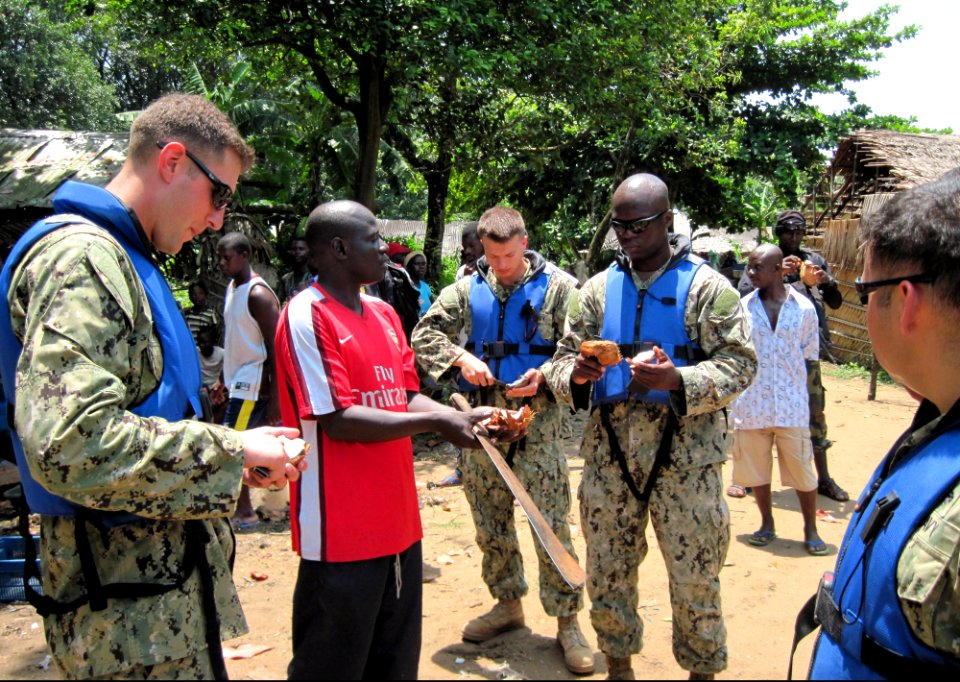 U.S. Sailors assigned to Naval Mobile Construction Battalion 4 share a coconut with residents during a site survey in preparation for building two new medical centers as part of Africa Partnership Station (APS) 130312-N-ZZ999-009