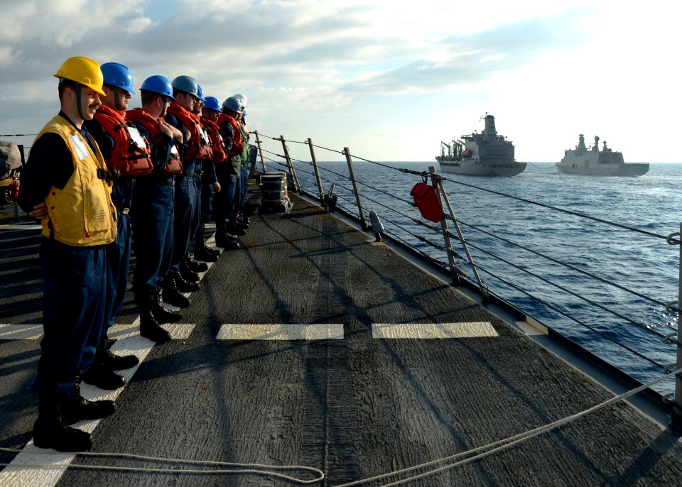 U.S. Sailors assigned to the guided missile destroyer USS Ramage (DDG 61) stand in formation as the ship makes its approach alongside the fleet replenishment oiler USNS John Lenthall (T-AO 189), center, to 140326-N-CH661-003
