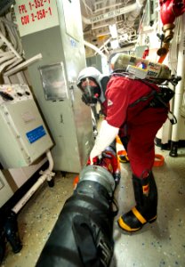 U.S. Navy Gunner's Mate Seaman Nicholas Funderburk positions a fan for proper ventilation during a toxic gas drill aboard the guided missile destroyer USS Ross (DDG 71) March 18, 2014, in the Atlantic Ocean 140318-N-WX580-070