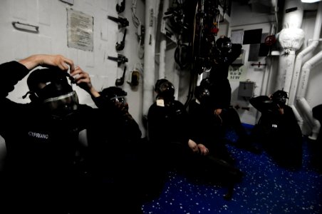 U.S. Sailors dawn their gas masks during a simulated chemical, biological, radiological attack scenario aboard the amphibious dock landing ship USS Comstock (LSD 45) March 14, 2011, while under way in 110314-N-RC734-038