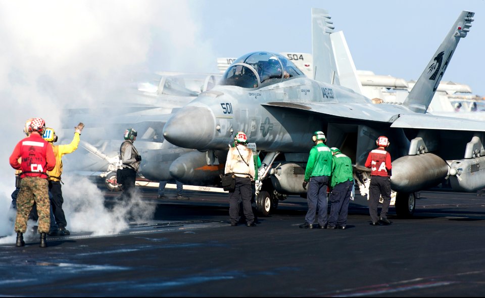 U.S. Sailors and Marines guide an EA-18G Growler aircraft assigned to Electronic Attack Squadron (VAQ) 130 onto a catapult on the flight deck of the aircraft carrier USS Harry S. Truman (CVN 75) March 8, 2014 140308-N-ZG705-028