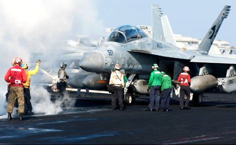 U.S. Sailors and Marines guide an EA-18G Growler aircraft assigned to Electronic Attack Squadron (VAQ) 130 onto a catapult on the flight deck of the aircraft carrier USS Harry S. Truman (CVN 75) March 8, 2014 140308-N-ZG705-028